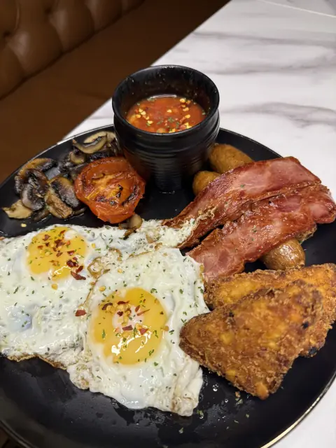 A medium breakfast with eggs, turkey rashers, sausages and hash browns