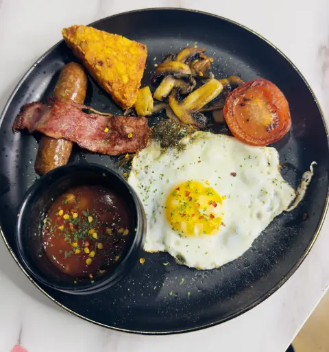 A small breakfast with a fried egg, sausage and turkey rasher